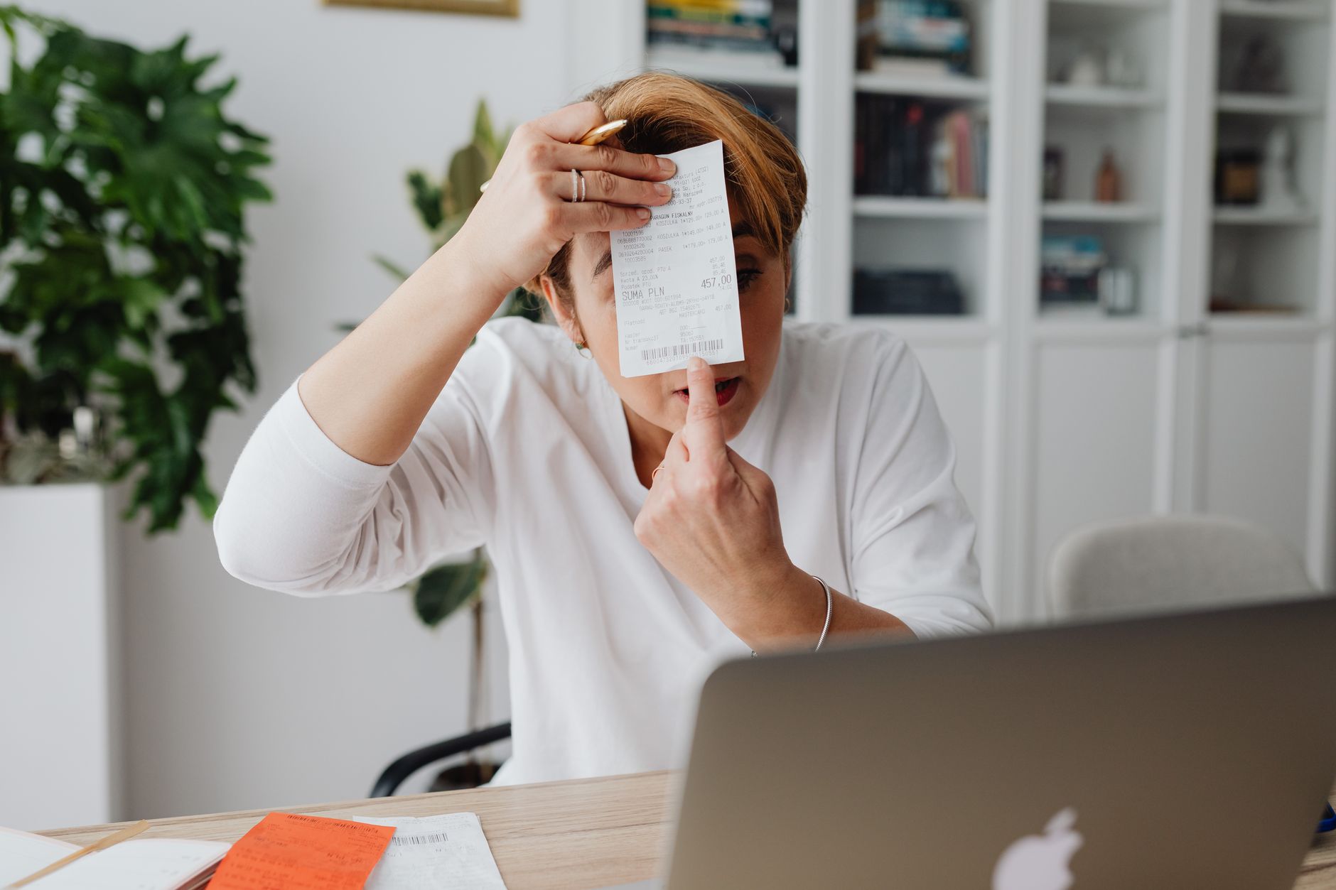 Traballador administrativo revisando facturas e presupostos en papel